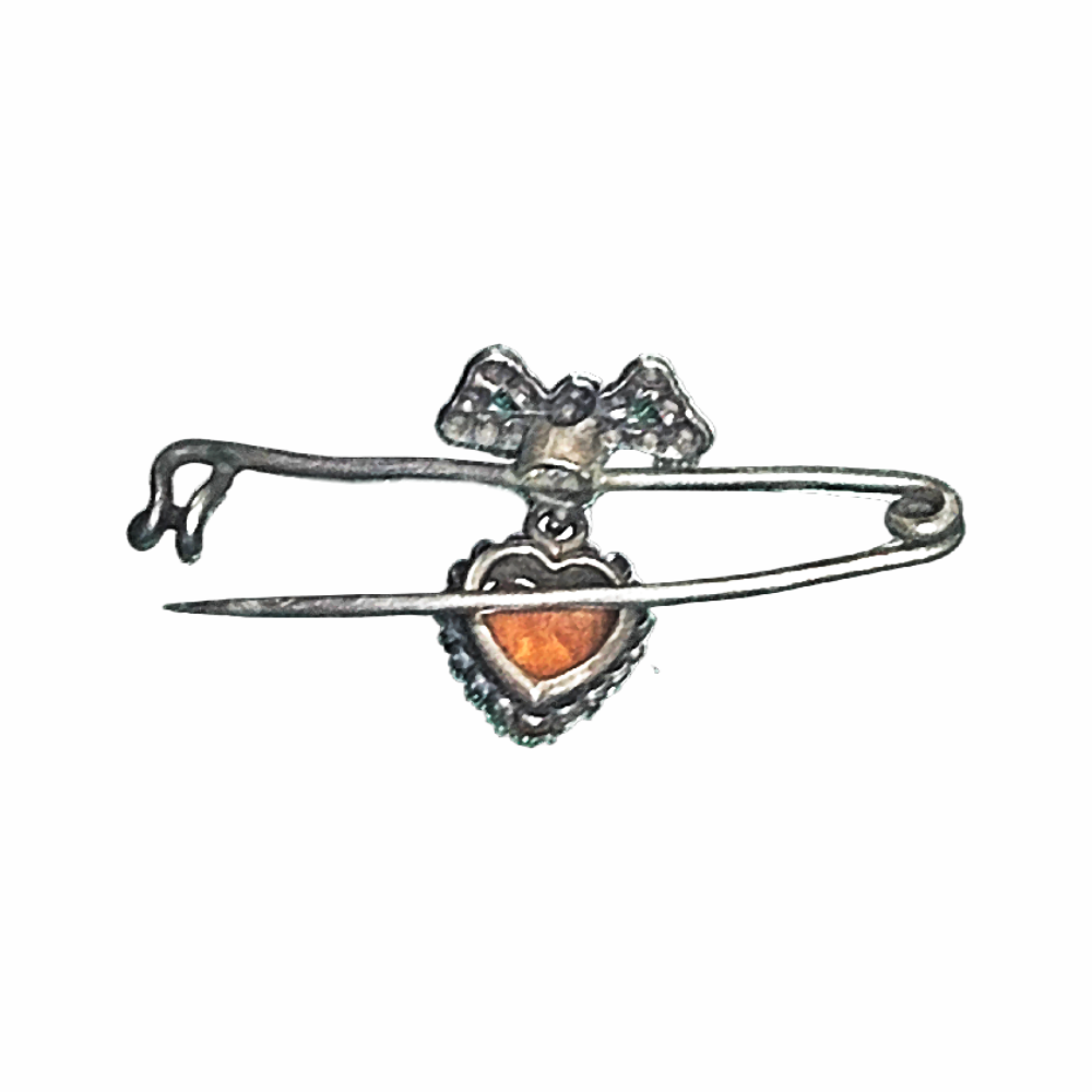Vintage 1930s–40s sweetheart safety pin brooch with sculpted bow and dangling orange heart cabochon. Romantic vintage costume jewellery.