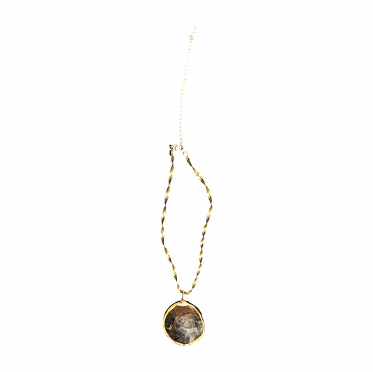 Vintage ammonite fossil pendant necklace with a polished natural spiral fossil, gold-tone surround and twisted herringbone-style chain.