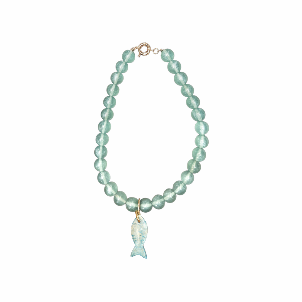 Vintage seafoam cat’s eye glass bead necklace with carved blue fish pendant, gold-tone fittings and coastal nautical styling.