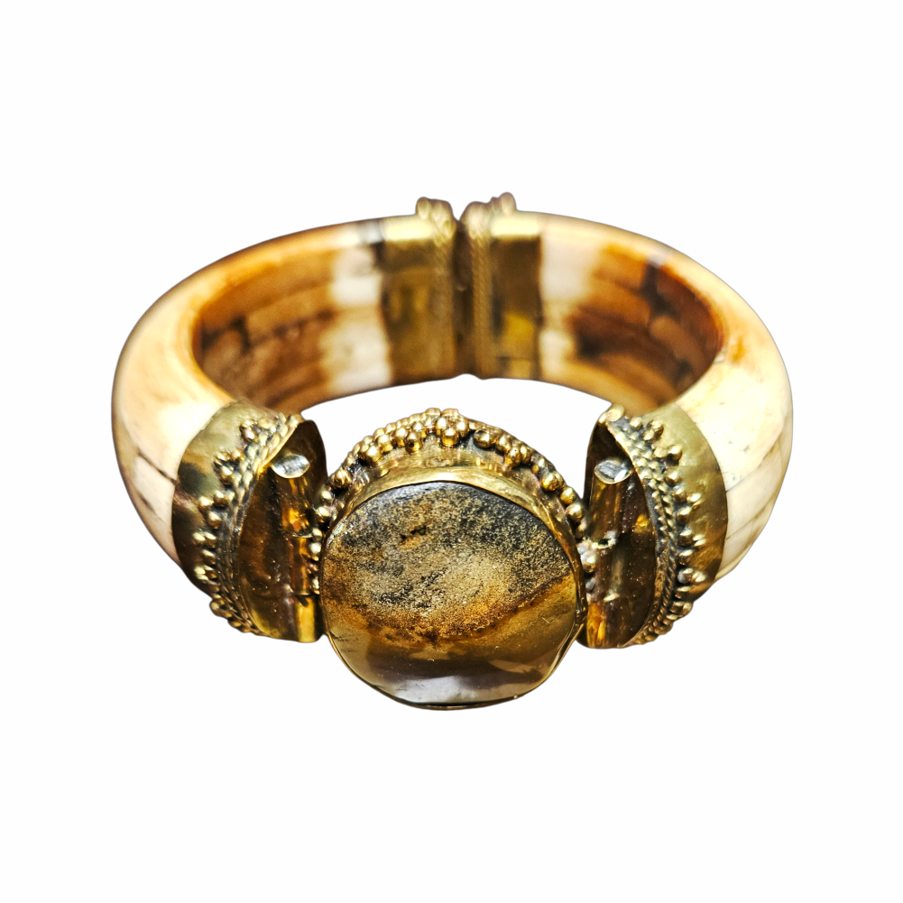 Vintage hinged statement cuff bracelet with bone-tone segments, ornate gold-tone metalwork and large smoky agate-effect cabochon. Bold tribal-inspired jewellery, circa 1980s.