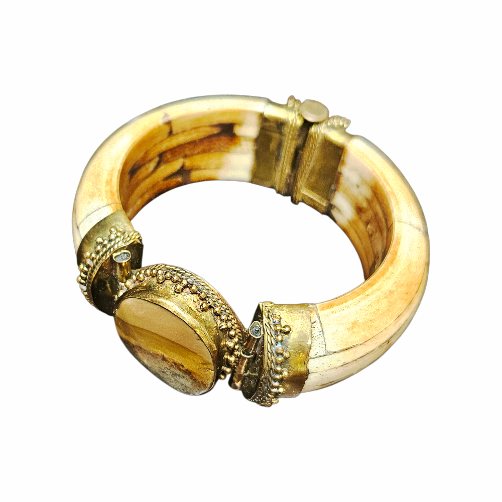 Vintage hinged statement cuff bracelet with bone-tone segments, ornate gold-tone metalwork and large smoky agate-effect cabochon. Bold tribal-inspired jewellery, circa 1980s.