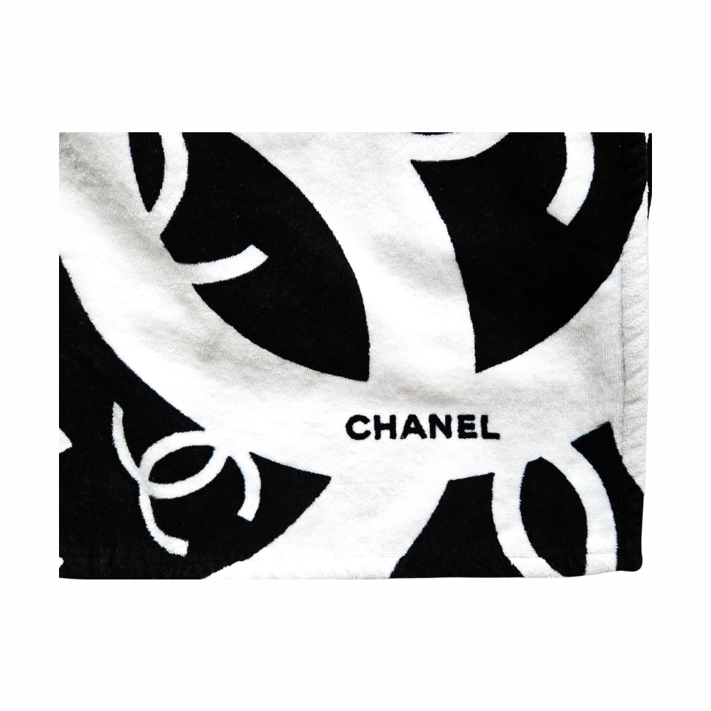 Close-up of CHANEL lettering on black and white interlocking CC logo cotton beach towel