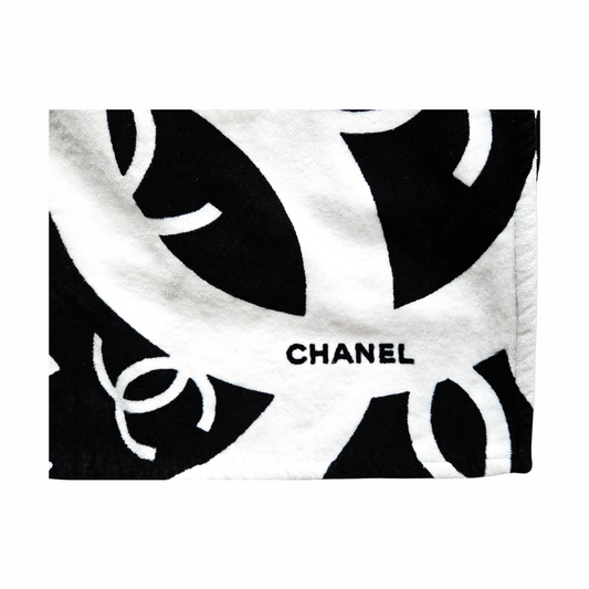 Close-up of CHANEL lettering on black and white interlocking CC logo cotton beach towel