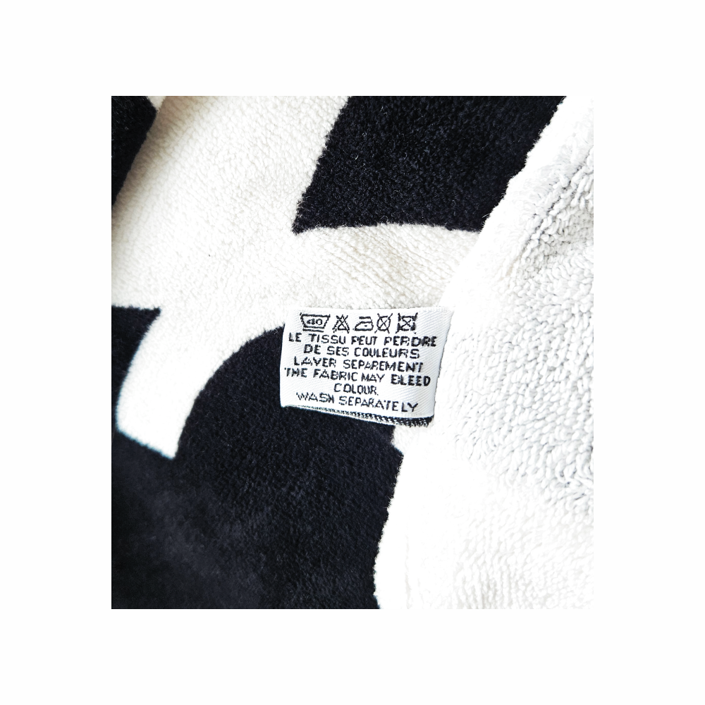 Original CHANEL beach towel care label showing washing instructions and textile composition information