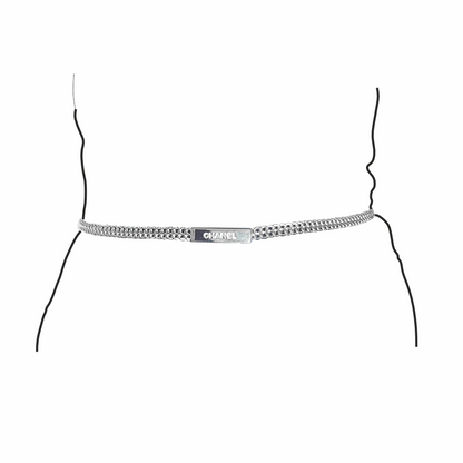 Detail of Vintage Chanel Spring 1999 silver-tone double chain belt with embossed CHANEL logo plaque on model silhouette