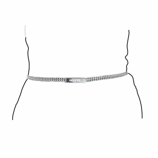 Detail of Vintage Chanel Spring 1999 silver-tone double chain belt with embossed CHANEL logo plaque on model silhouette
