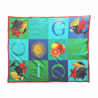 Shop a vintage Gucci cotton pareo, circa 1980s–1990s, featuring a colourful marine, citrus and sun print with oversized GUCCI lettering.