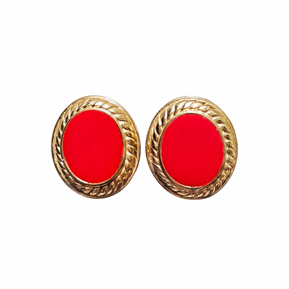 Vintage 1980s Monet red oval clip-on earrings with glossy cabochon-style centres, textured gold-tone frames and signed Monet backs.