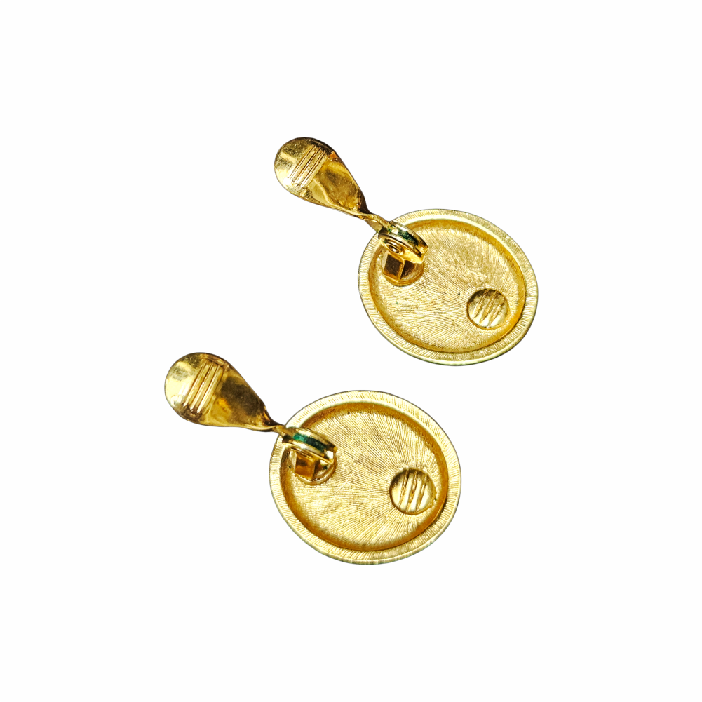 Vintage 1980s Monet red oval clip-on earrings with glossy cabochon-style centres, textured gold-tone frames and signed Monet backs.