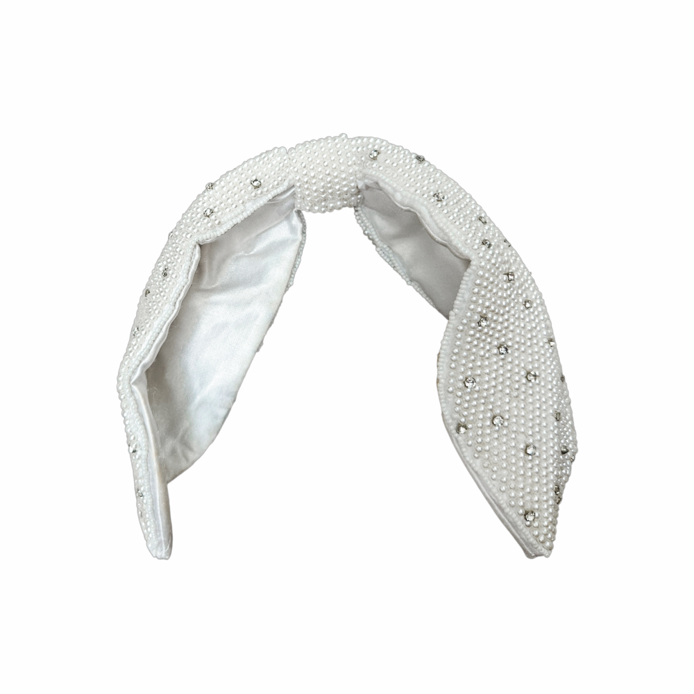 White faux pearl and crystal bow headband with padded construction and satin lining, ideal for bridal and occasion wear.
