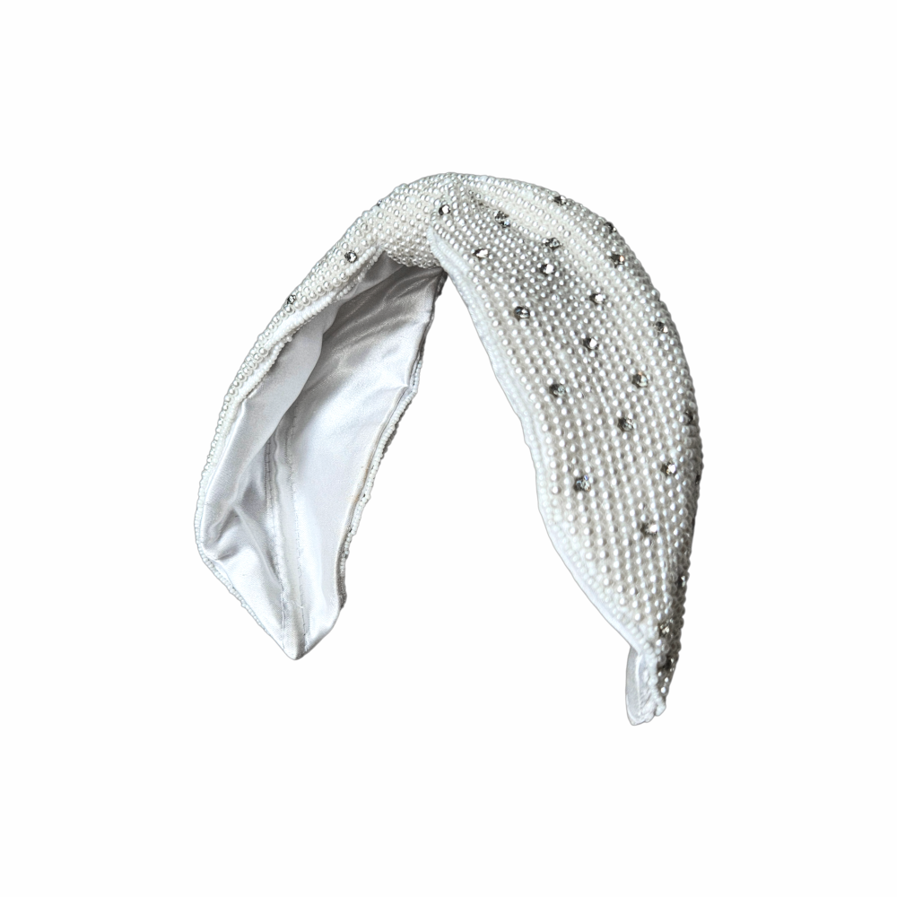 White faux pearl and crystal bow headband with padded construction and satin lining, ideal for bridal and occasion wear.
