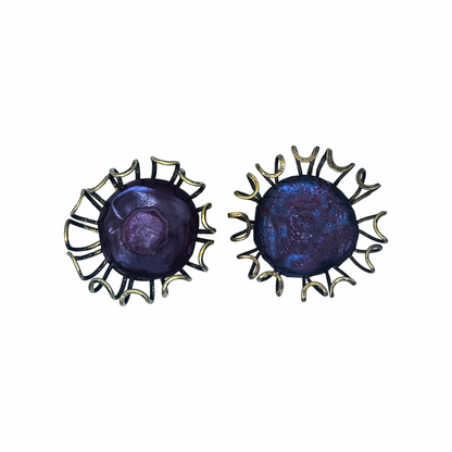 Oversized artisan brutalist vintage clip-on earrings with purple glass centres and sculptural brass-tone cage detailing, approx. 5 cm diameter.